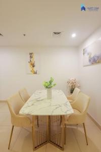 a dining room table and chairs with a white table at Elegant 2BR near Palm Jumeirah - 6 Min Drive in Dubai