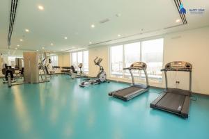 un gimnasio con suelo azul y máquinas de ejercicio en Elegant 2BR near Palm Jumeirah - 6 Min Drive, en Dubái