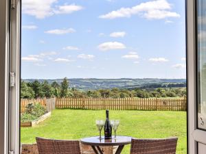 a table with two wine glasses and a window at Jasmine Cottage in Knitsley