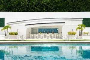 uma piscina em frente a uma casa com um bar em JW Marriott Miami em Miami