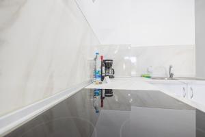 a white kitchen with a sink and a counter at Lightbooking 7 Palmas in Las Palmas de Gran Canaria