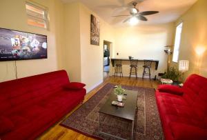 a living room with a red couch and a table at Tuk Ahoy - Emerald Suite 3C with Shared Spaces in Brooklyn