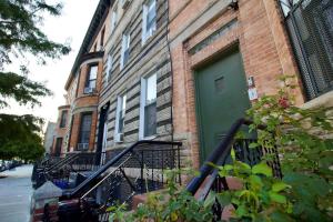 a building with a green door on a street at Tuk Ahoy - Emerald Suite 3C with Shared Spaces in Brooklyn