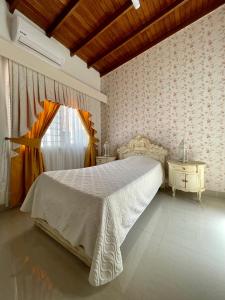 1 dormitorio con 1 cama, 2 mesas y una ventana en Casa completa, para familia numerosa o eventos. en Medellín