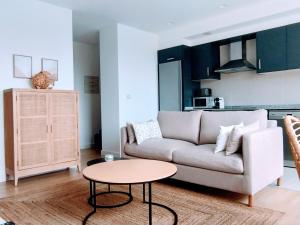 ein Wohnzimmer mit einem Sofa und einem Tisch in der Unterkunft Apartamento en Sada con piscina in Sada