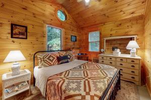 um quarto com uma cama num chalé de madeira em Beebe Pond Paradise em Castleton