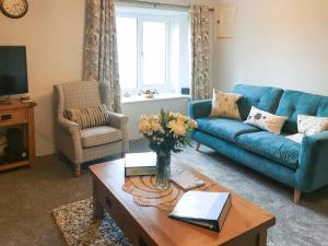 sala de estar con sofá azul y mesa en Greenpastures en Beaworthy
