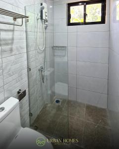 a bathroom with a shower with a glass door at Urban Homes Bohol in Tagbilaran City