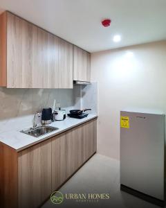 a kitchen with a sink and a refrigerator at Urban Homes Bohol in Tagbilaran City