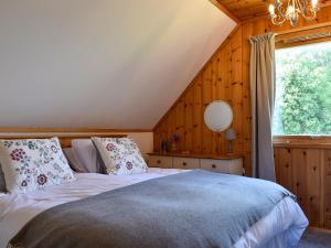 1 dormitorio con cama y ventana grande en Hadrians Garden Cottage - Uk3323, en Bardon Mill