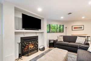a living room with a fireplace with a flat screen tv at The Tulip Tree House in New Buffalo