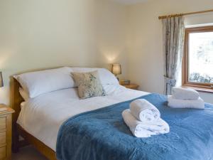 1 dormitorio con 1 cama con toallas en The Old Candle House en Longnor