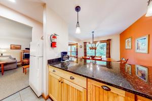 a kitchen with a large counter top and a living room at Trail Creek 20 in Killington