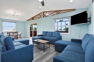Il comprend un salon doté de canapés bleus et d'une télévision à écran plat. dans l'établissement Coral Cottage, à Weeki Wachee