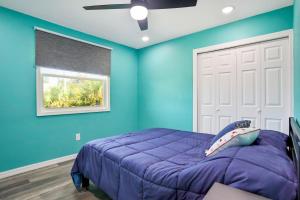 - une chambre bleue avec un lit et une fenêtre dans l'établissement Coral Cottage, à Weeki Wachee