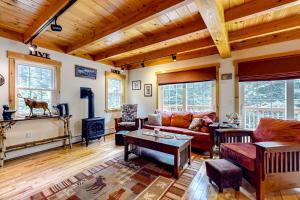 una sala de estar con muebles y techo de madera. en Sugarloaf Chalet, en Carrabassett