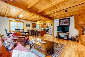 een woonkamer met een bank en een tafel bij Sugarloaf Chalet in Carrabassett