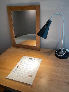 a desk with a mirror and a lamp and a sign at soco rooms in Kyoto