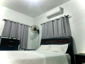 a bedroom with a bed with curtains and a fan at Casa Linda 10 mins from Beach-Lagoon in Payita