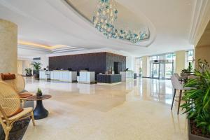 een lobby met een kroonluchter en tafels en stoelen bij Malta Marriott Resort & Spa in St Julian's