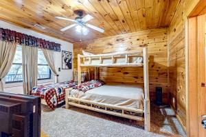 1 Schlafzimmer mit 2 Etagenbetten in einem Blockhaus in der Unterkunft Cherokee Sunrise Cabin in Mineral Bluff