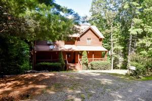ein Blockhaus mit einer Einfahrt davor in der Unterkunft Cherokee Sunrise Cabin in Mineral Bluff