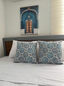 a bed with two pillows and a picture of a door at Apartamentos Magallanes Romana in La Romana