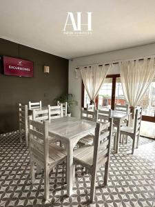a dining room with a white table and chairs at American Hoteles in Villa Carlos Paz