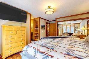 1 dormitorio con 1 cama grande, vestidor y TV en Salmon 8 en Welches