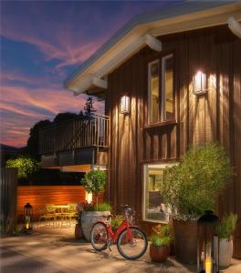 una bicicleta roja estacionada frente a una casa en The Cottages Hotel, en Menlo Park