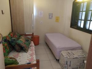 una piccola stanza con due letti e un divano di Casa da San a Mongaguá Altre 14 foto