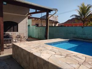 una piscina accanto a una casa con una recinzione di Casa da San a Mongaguá