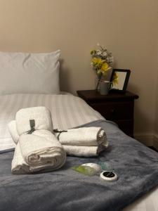 a bed with towels on top of a bed at Stratford Guest House By Cosystays in London