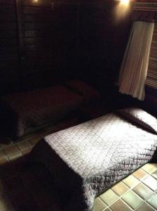 a bedroom with a bed in a dark room at Chalé das Helicônias in Guaramiranga
