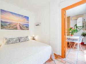 a white bedroom with a bed and a desk at Valencia Apartamento centro old town in Valencia