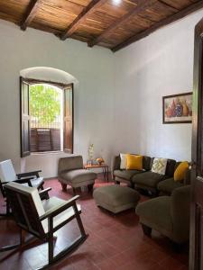 a living room with couches and chairs and a window at Casa Colonial in Suchitoto