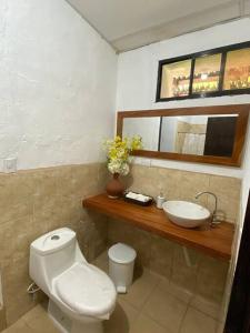 a bathroom with a white toilet and a sink at Casa Colonial in Suchitoto