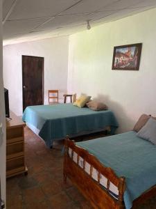 a bedroom with two beds and a television in it at Casa Colonial in Suchitoto