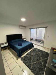 a bedroom with a bed and a large window at Casa Tulum in Villa del Pueblito