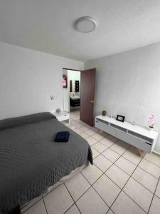 a bedroom with a bed and a tile floor at Casa Tulum in Villa del Pueblito