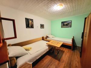 a room with two beds and a table in it at Ciconia Nigra rooms in Bački Monoštor