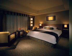 una camera d'albergo con un grande letto e una sedia di Hotel Okura Kyoto a Kyoto
