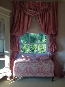 a bedroom with a bed and a window with curtains at Westbrook Country House in Castlebar