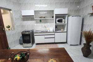 uma cozinha com armários brancos e um frigorífico em CASA DOS SINOS em São João del Rei