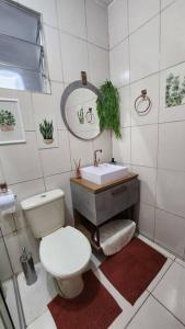 uma casa de banho com um WC branco e um lavatório. em CASA DOS SINOS em São João del Rei