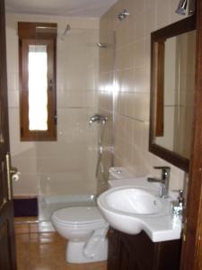een badkamer met een wastafel, een toilet en een bad bij Cornatel Médulas in Borrenes