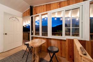 um quarto com uma janela, uma mesa e bancos em Cabaña de montaña Boquete em Bajo Boquete
