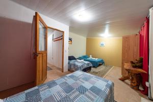 1 dormitorio con 2 camas y 1 habitación con espejo en Cabaña de montaña Boquete, en Bajo Boquete