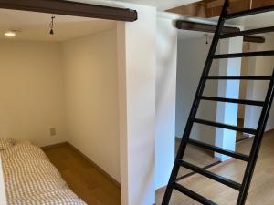 Una escalera en un dormitorio con litera en 民宿 和合 Minshuku WAGO en Tanabe