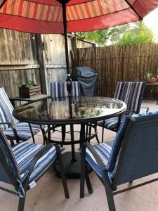 a glass table with chairs and an umbrella on a patio at Santa Barbara Serenity Large 1-bedroom Guest Apt. in Santa Barbara